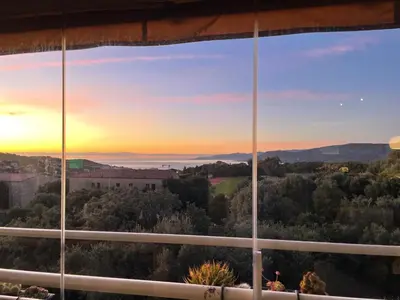 a view from a window of a sunset at appartement Vue mer époustouflante in Propriano