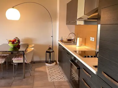 a kitchen with a table with a bowl of fruit on it at appartement Vue mer époustouflante in Propriano