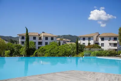 a large swimming pool with buildings in the background at Domaine d'Arca - Flaubert 10 - 4 pers in Porto-Vecchio