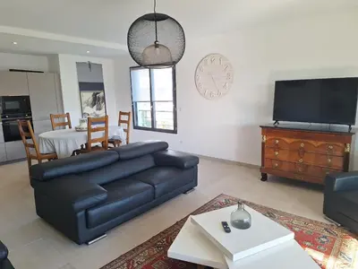 a living room with a black leather couch and a tv at Domaine d'Arca - Flaubert 10 - 4 pers in Porto-Vecchio