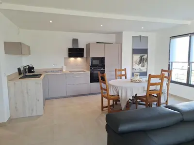 a kitchen and living room with a table and chairs at Domaine d'Arca - Flaubert 10 - 4 pers in Porto-Vecchio