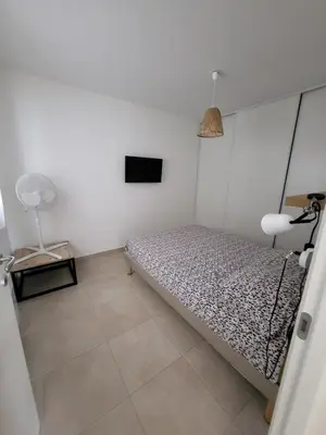 a small bedroom with a bed and a fan at Residence Marina di Bravone in Linguizzetta