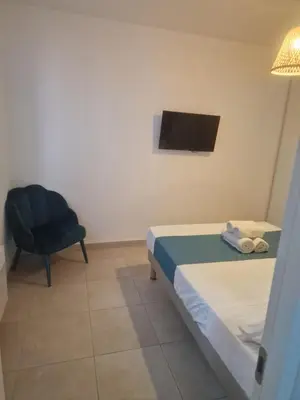 a bedroom with a bed and a chair and a television at Residence Marina di Bravone in Linguizzetta