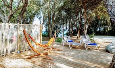 a woman lying in a hammock overlooking the ocean at Les villas de Bagheera, oasis naturiste in Linguizzetta