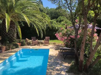 a swimming pool in a yard with a palm tree at Casa de Patarra Villa avec piscine privée dans un havre de paix in Peri