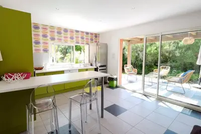 a kitchen with green walls and a table and chairs at Casa de Patarra Villa avec piscine privée dans un havre de paix in Peri