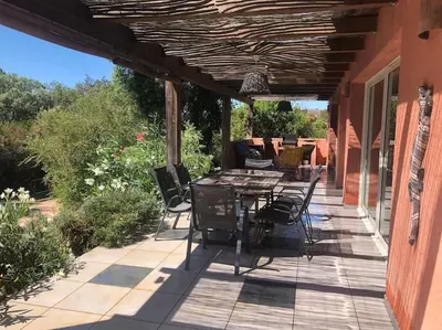 a patio with a table and chairs on a house at Casa de Patarra Villa avec piscine privée dans un havre de paix in Peri