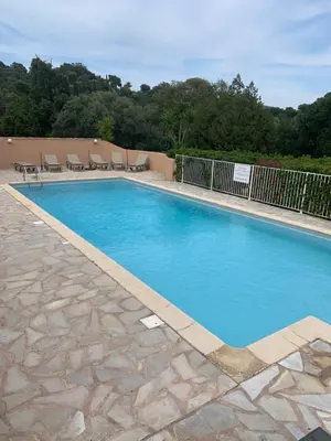 a large swimming pool with blue water at Résidence U LATONU in Porto-Vecchio