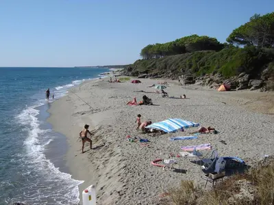 a group of people on a beach near the water at Appartamento con 2 camere da letto a 200 m dalla spiaggia in Linguizzetta