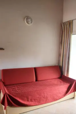 a red couch sitting in a room with a window at Appartamento con 2 camere da letto a 200 m dalla spiaggia in Linguizzetta