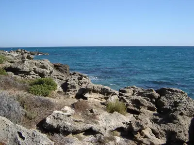 a group of rocks with the ocean in the background at Appartamento con 2 camere da letto a 200 m dalla spiaggia in Linguizzetta