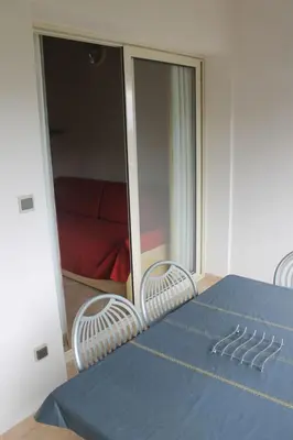 a room with a blue table and two chairs and a bedroom at Appartamento con 2 camere da letto a 200 m dalla spiaggia in Linguizzetta