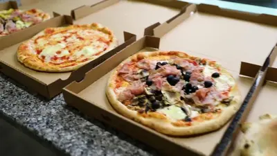 three pizzas in boxes sitting on a counter at Vignale Resort in Ghisonaccia