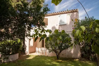 a white house with chairs and a yard at Vignale Resort in Ghisonaccia