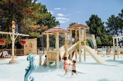 two children playing on a slide at a water park at Vignale Resort in Ghisonaccia