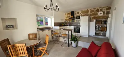 a kitchen with a table and a dining room at T2 typique au cœur du village et vue sur le Golfe in Olmeto