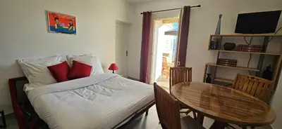 a bedroom with a bed and a table and a window at T2 typique au cœur du village et vue sur le Golfe in Olmeto
