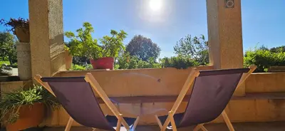 two purple chairs sitting next to a table on a patio at T3 paisible quartier Vigna Maggiore, Olmeto in Olmeto