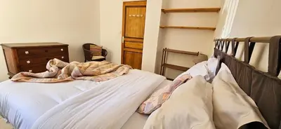 a bedroom with a bed with a wooden headboard and a dresser at T3 paisible quartier Vigna Maggiore, Olmeto in Olmeto