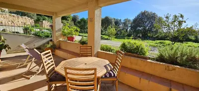 a patio with a table and chairs on a porch at T3 paisible quartier Vigna Maggiore, Olmeto in Olmeto