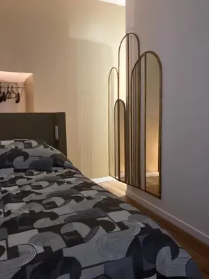 a bedroom with a bed and a large mirror at STUDIO SPACIEUX TOUT CONFORT CITE IMPERIALE in Ajaccio