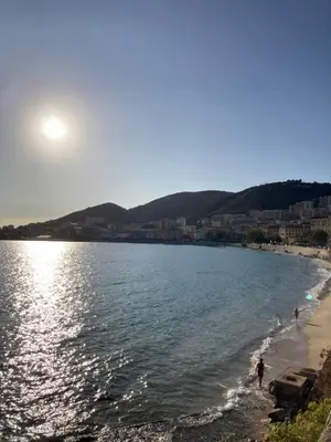 a beach with people walking on the beach at STUDIO SPACIEUX TOUT CONFORT CITE IMPERIALE in Ajaccio