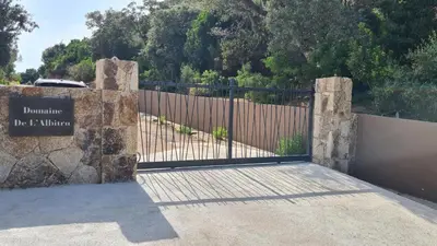 a gate with a sign in front of a fence at Appartement RDJ ds villa vue mer panoramique in Lecci