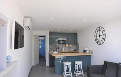 a kitchen with a counter and stools in a room at Appartement RDJ ds villa vue mer panoramique in Lecci