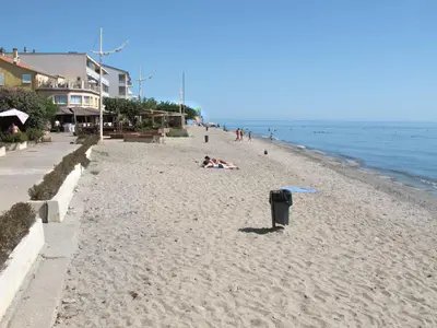 a group of people laying on the beach at Apartment MB4 by Interhome in Moriani Plage