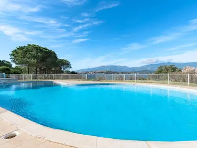 a large blue swimming pool with a fence at Apartment Casetta Bianca by Interhome in Porto-Vecchio