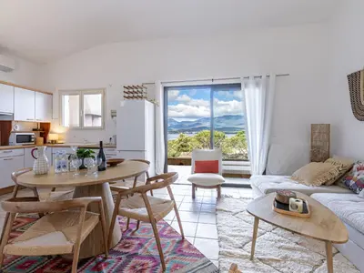 a kitchen and a living room with a table and a couch at Apartment Casetta Bianca by Interhome in Porto-Vecchio