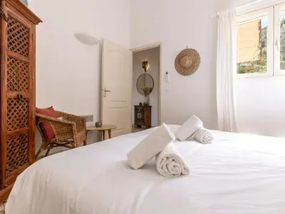 a bedroom with a white bed with towels on it at Apartment Casetta Bianca by Interhome in Porto-Vecchio