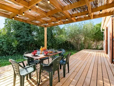 a patio with a table and chairs on a wooden deck at Holiday Home Turriccioli by Interhome in Porto-Vecchio