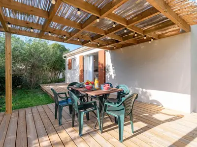 a patio with a table and chairs on a deck at Holiday Home Turriccioli by Interhome in Porto-Vecchio