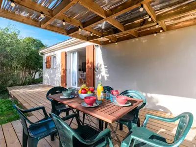 a wooden table and chairs on a patio at Holiday Home Turriccioli by Interhome in Porto-Vecchio