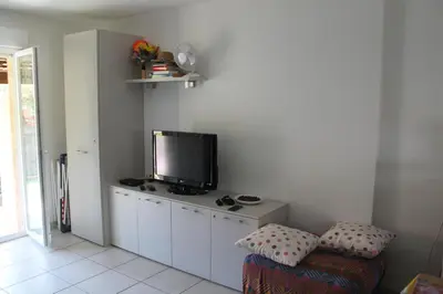 a living room with a flat screen tv on a cabinet at Graziosa villetta in residence con piscina a 100 m dalla spiaggia in Cervione