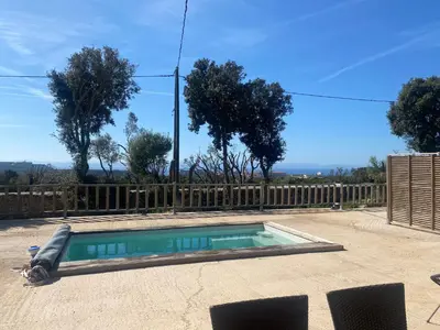 a swimming pool in a yard with a wooden fence at Petit chalet d’été avec piscine privée chauffée in Bonifacio