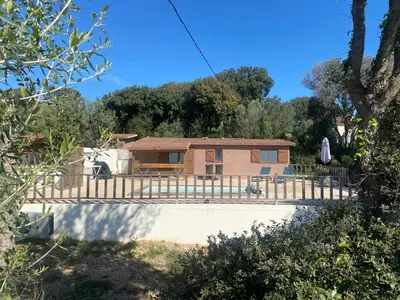 a house with a gate and a fence at Petit chalet d’été avec piscine privée chauffée in Bonifacio