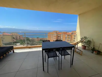 a table and chairs on a balcony with a view at Appartement T3 face à la mer in Ajaccio