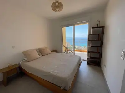 a bedroom with a bed and a large window at Appartement T3 face à la mer in Ajaccio