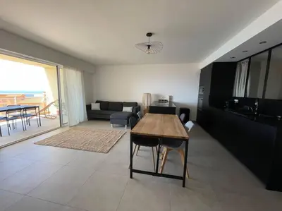 a living room with a table and a couch at Appartement T3 face à la mer in Ajaccio
