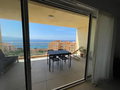 a balcony with a table and a view of the ocean at Appartement T3 face à la mer in Ajaccio