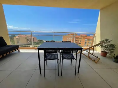 a table and chairs on a balcony with a view at Appartement T3 face à la mer in Ajaccio