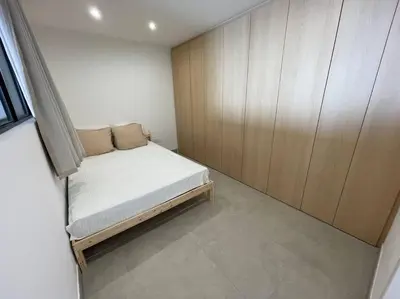 a small bedroom with a bed and a wooden cabinet at Appartement T3 face à la mer in Ajaccio