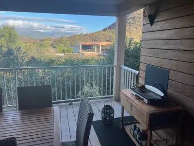 a balcony with a table and chairs on a deck at Appartement & Piscine Santa Giulia in Porto-Vecchio
