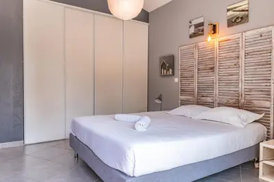 a bedroom with a large bed with white sheets at Villa U Meribellu Di Santa Lucia in Sainte-Lucie de Porto-Vecchio