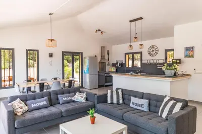 a living room with two couches and a kitchen at Villa U Meribellu Di Santa Lucia in Sainte-Lucie de Porto-Vecchio