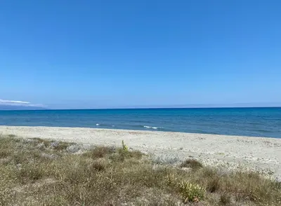 an empty beach with the ocean in the background at Résidence les chênes in Borgo