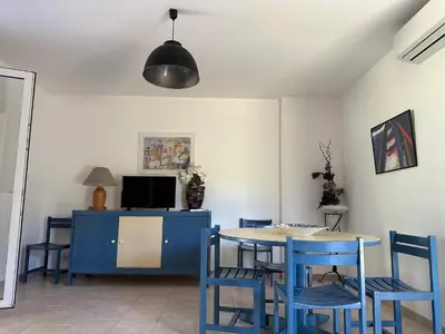 a dining room with a blue table and chairs at Résidence les chênes in Borgo
