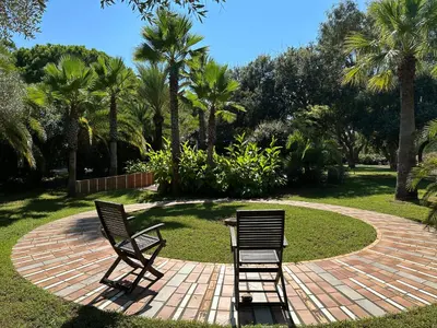 two chairs and a table on a brick patio at Résidence les chênes in Borgo